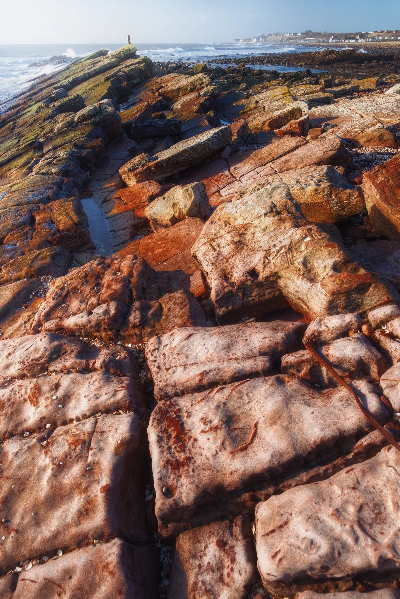  What you&rsquo;re looking at is from a time between 359 and 299 million years ago. The reddish-brown rocks contain a lot of iron oxide and were formed when Scotland was near the equator in a warm climate. The layers of sandstone and mudstone show how they were built up in ancient shallow seas and river deltas. Over the years, shifts in the earth&rsquo;s crust created the rectangular patterns you see, and the coast being worn away by waves shaped this impressive platform. 