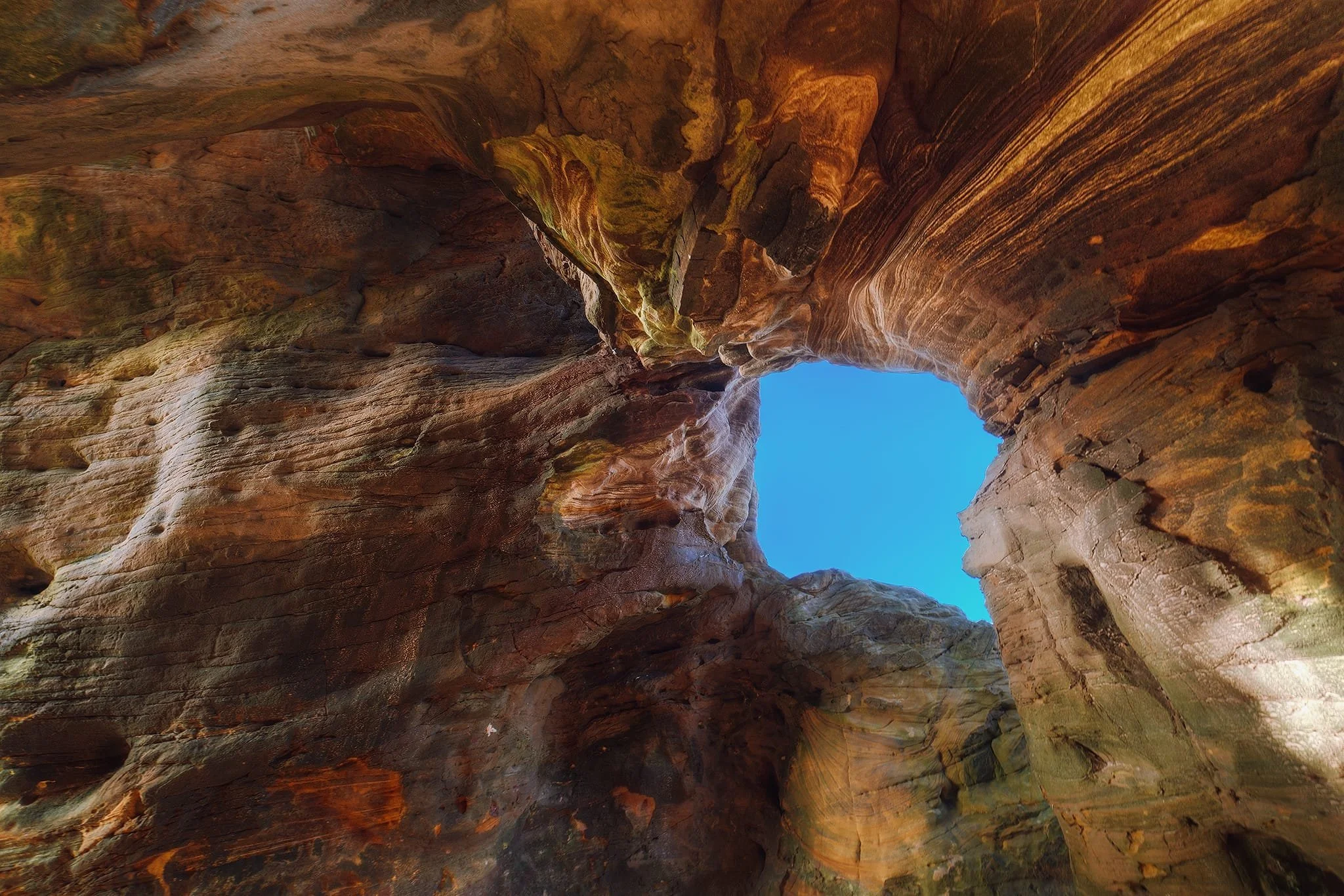  Like an over-excited child, I equipped my ultra-wide 14mm lens and went hunting for compositions. In the bigger cave I spotted a small &ldquo;window&rdquo; and used the incredible patterns and formations in the rocks to serve as a compositional leading line. 
