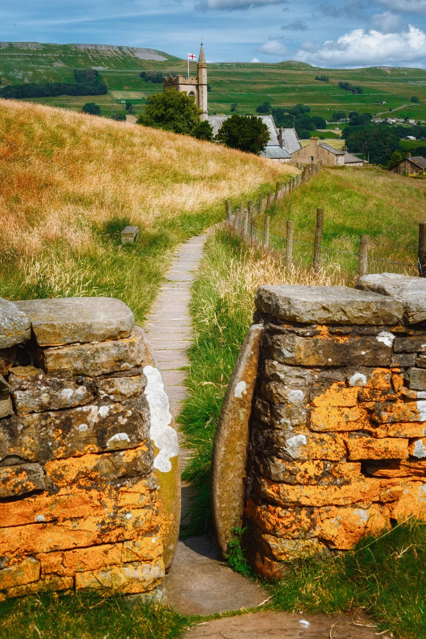 St. Margaret’s Church flying the St. George’s flag, the Pennine Way serving as a leading line into the composition. In the distance are the High and Low Clints of Stags Fell.
