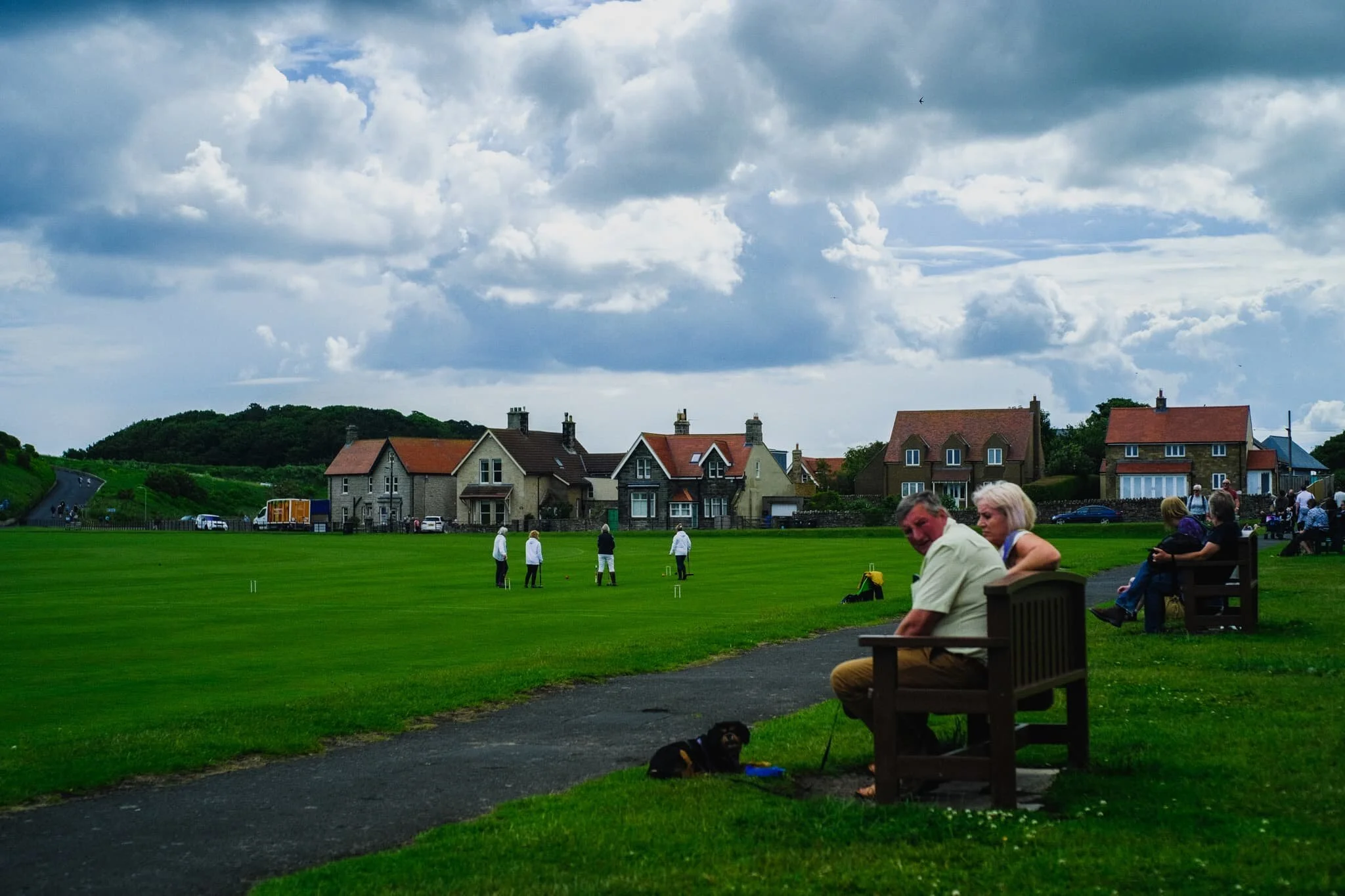  Seemingly oblivious to the approaching storm about to drench them in rain, a group of friends enjoy a game of croquet in the fields next to Bamburgh Castle. 