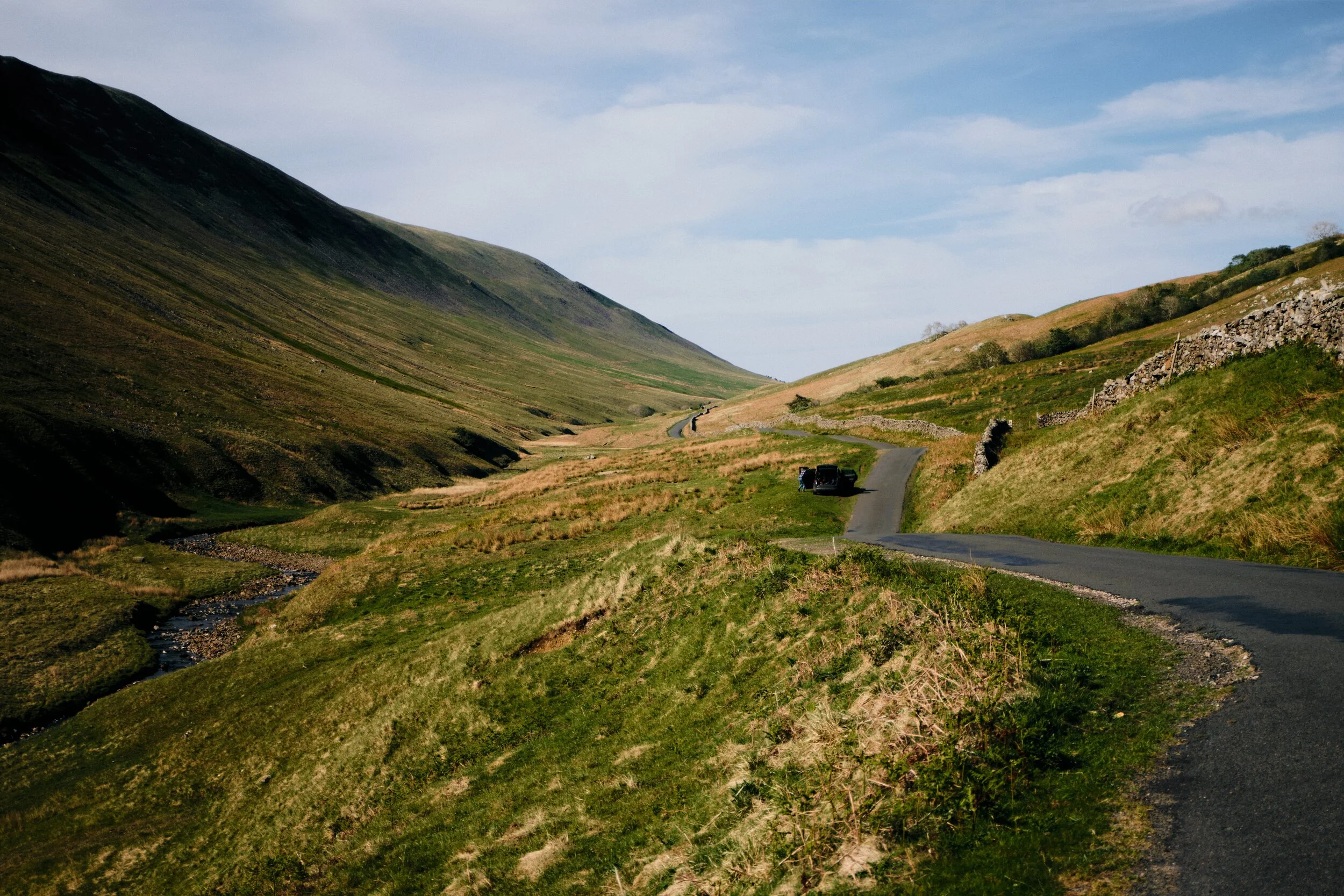 Upper Barbondale, featuring the precipitous shoulder of Calf Top (610 m/2,000 ft) and the winding road towards Dentdale.
