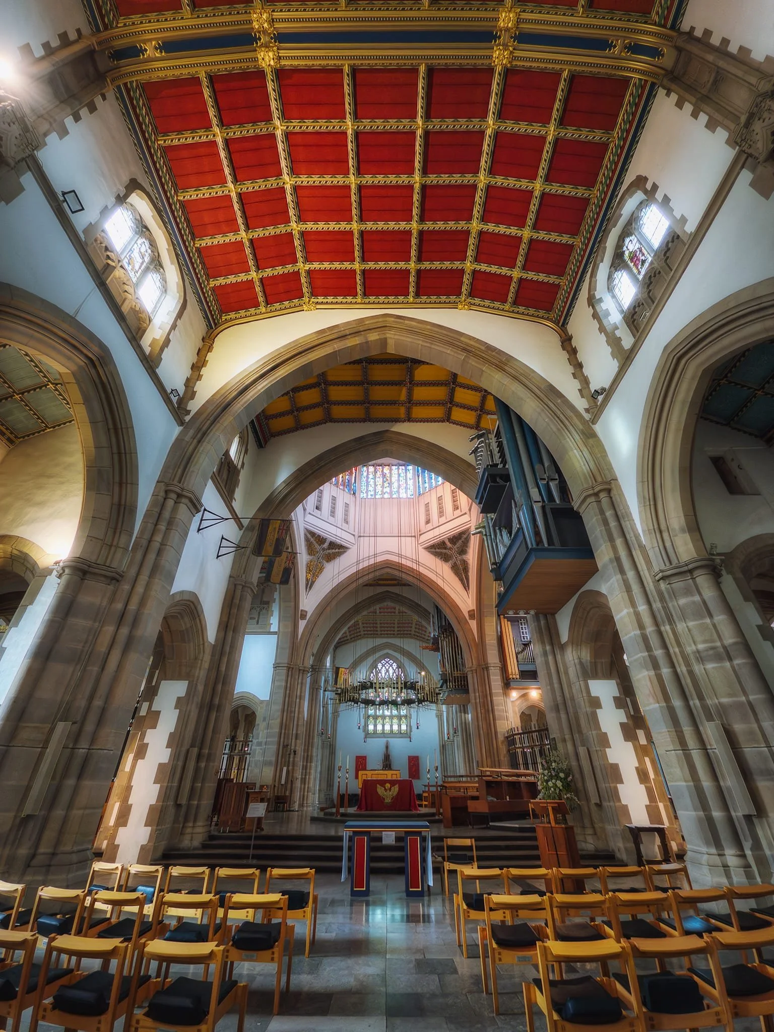 The transept and sanctuary, with the base of the lantern tower’s colourful glass just visible.