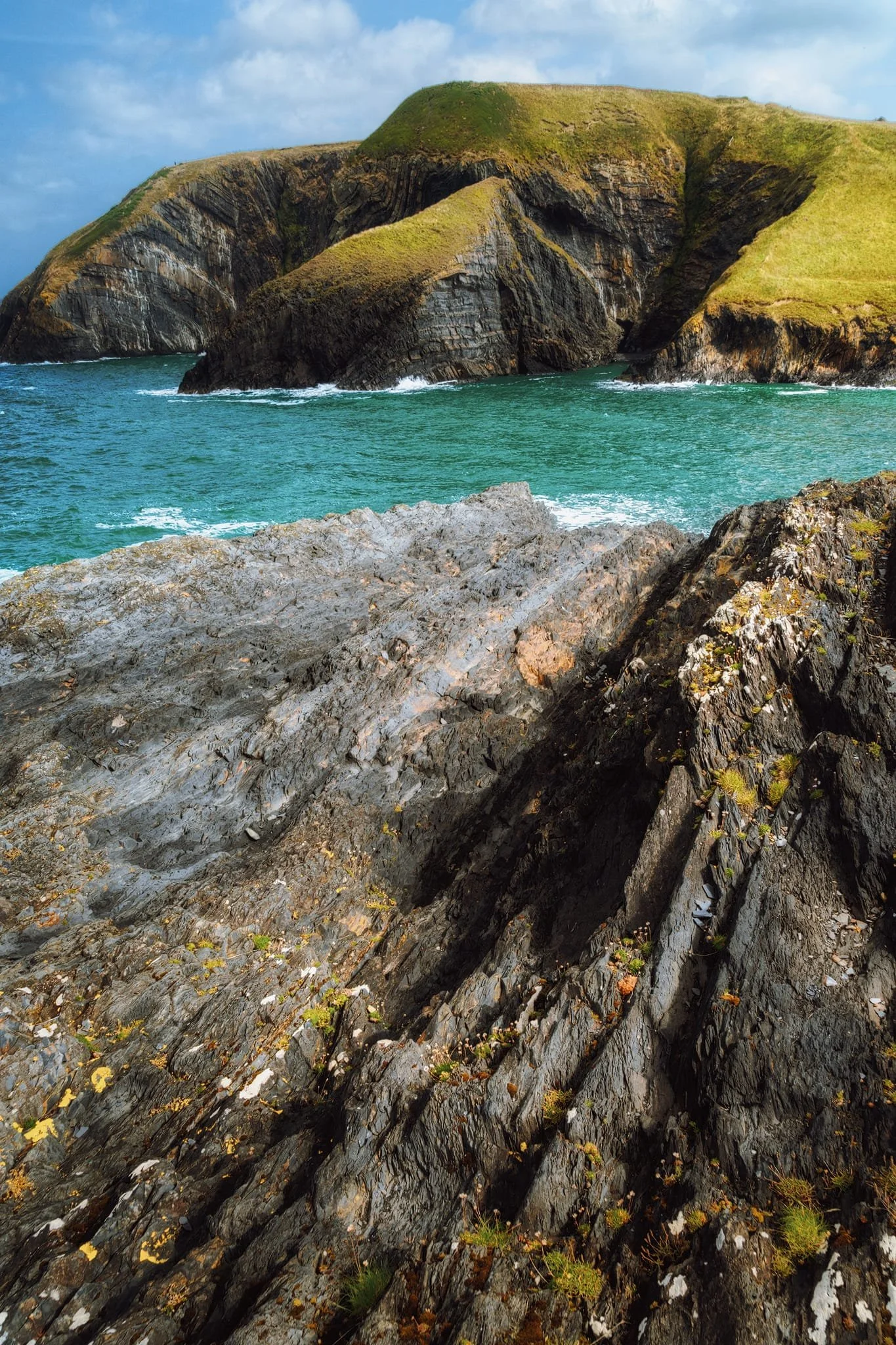  In fact, part way up the western  clifftop path a small desire line branches off back down towards the sea. We followed it, finding these amazing folds and grooved formations, which I used as leading lines towards the folded cliffs. 