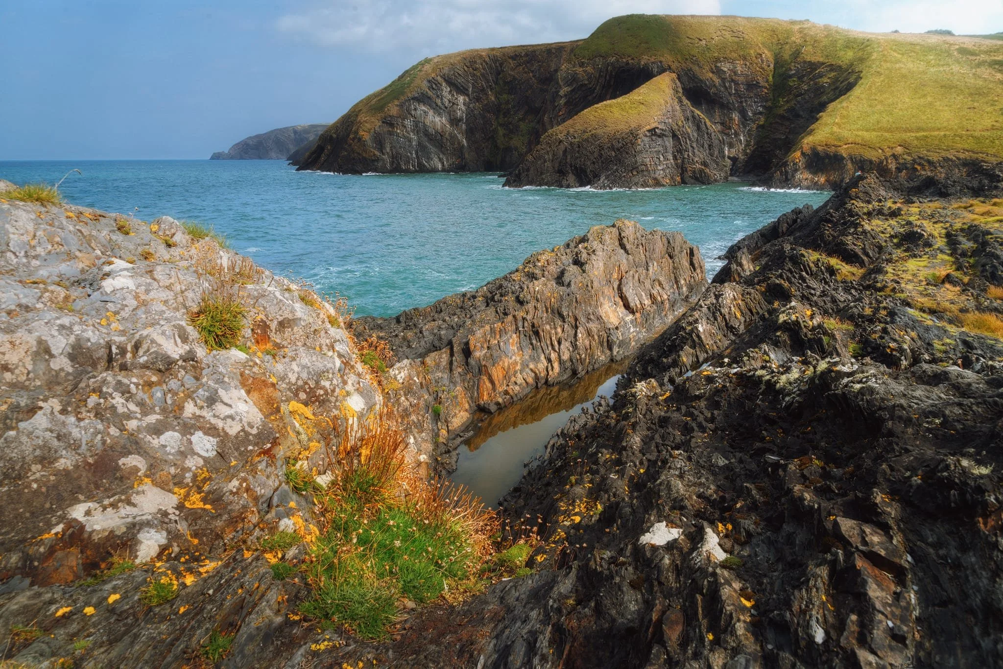  Before heading back up onto the clifftop trail, I sought a wider composition of these otherworldly folds and fins, using them as a leading line towards the deeply incised cliffs of Ceibwr. 