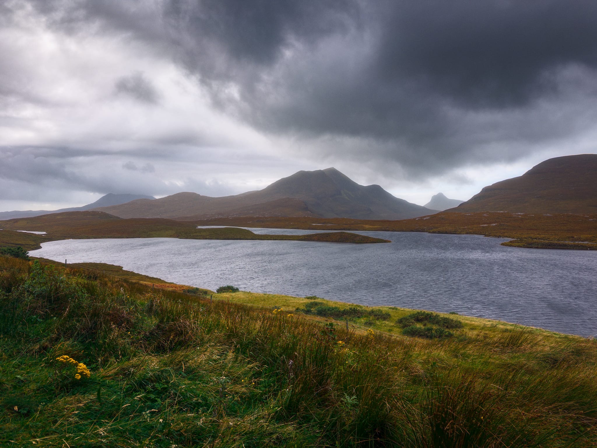 A wider composition from the same vantage point. I really tried to give this photo the impression of everything being battered by the storm&rsquo;s winds; grass swaying wildly, ripples racing across the lochan, and mobile clouds crashing into each other. 