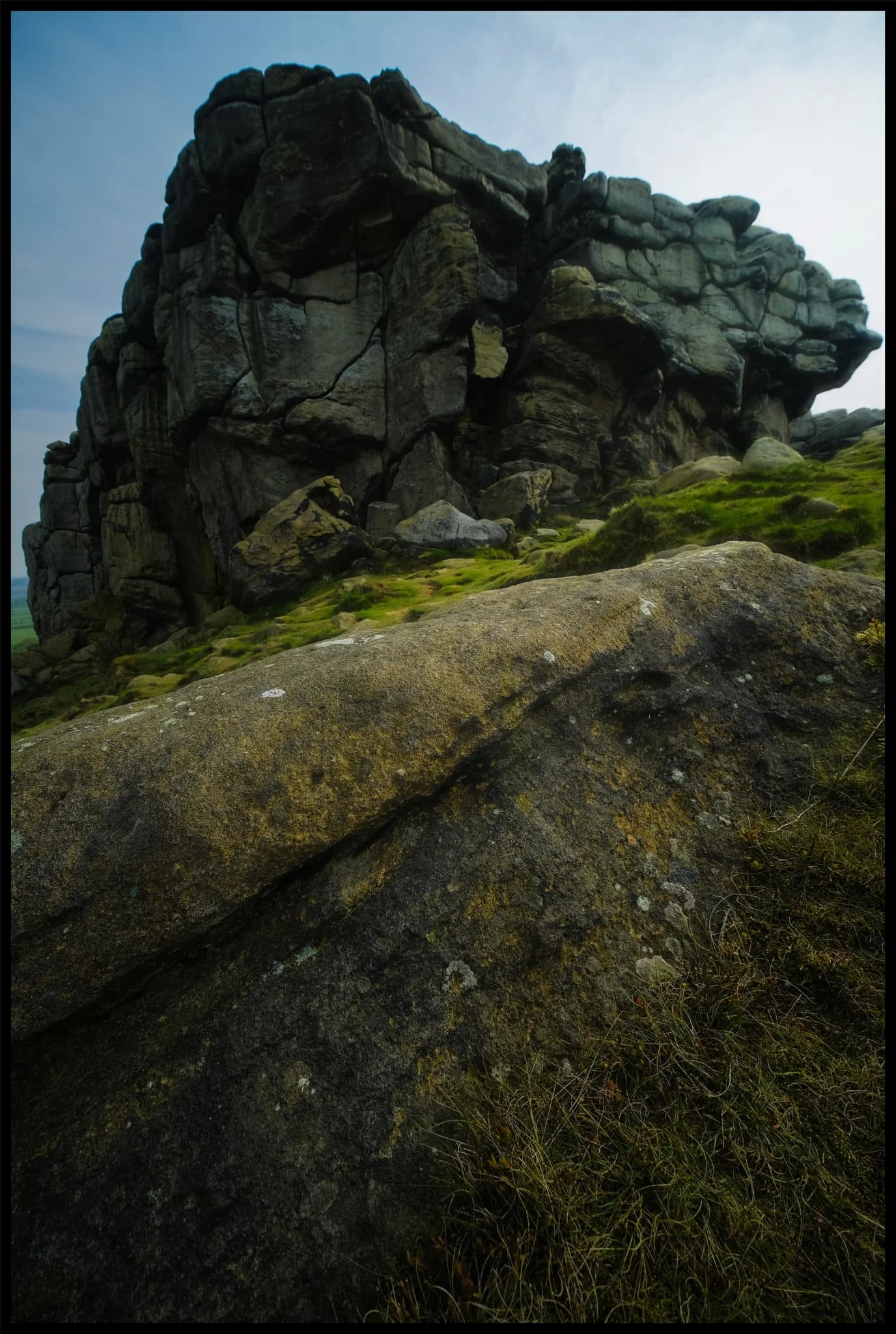  Directly beneath the crag that marks the highest point of the hill. 