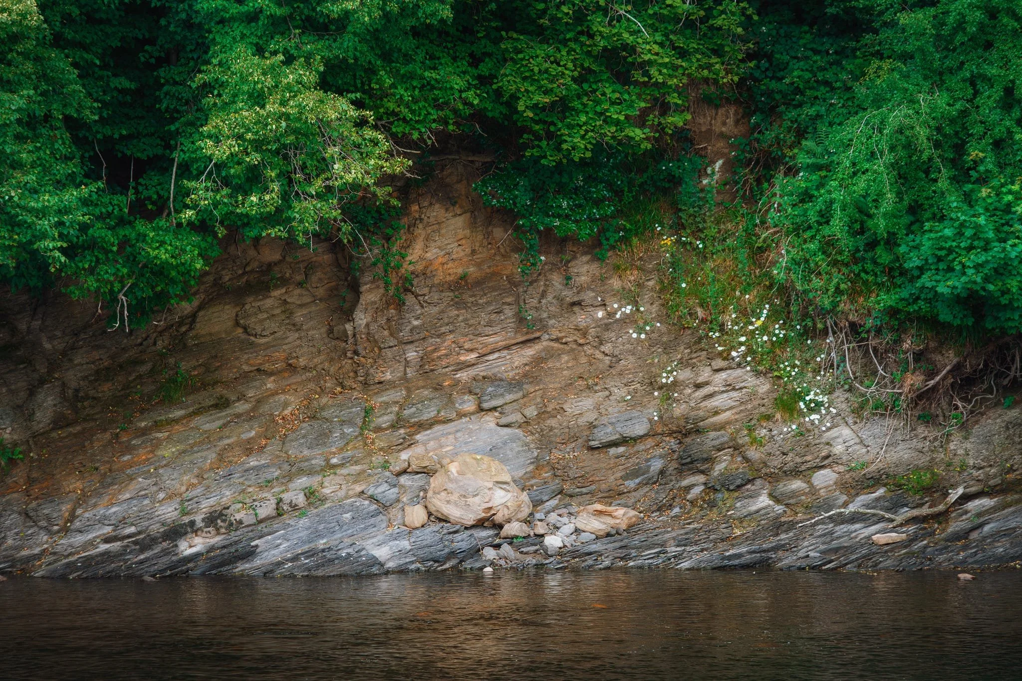 Over the course of eons, the Lune has scoured away the foot of View Field hill, revealing millions of years of historical geology.