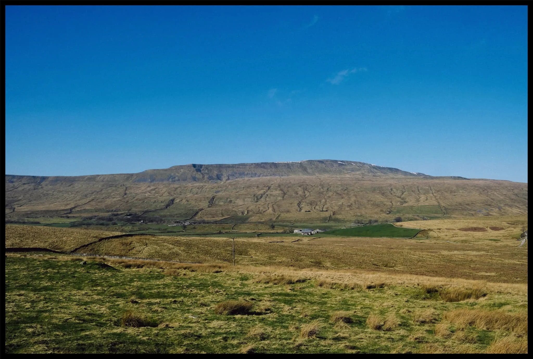  Whernside&rsquo;s eastern face, with a smidge of snow still clinging on. Barely a cloud in the sky. 
