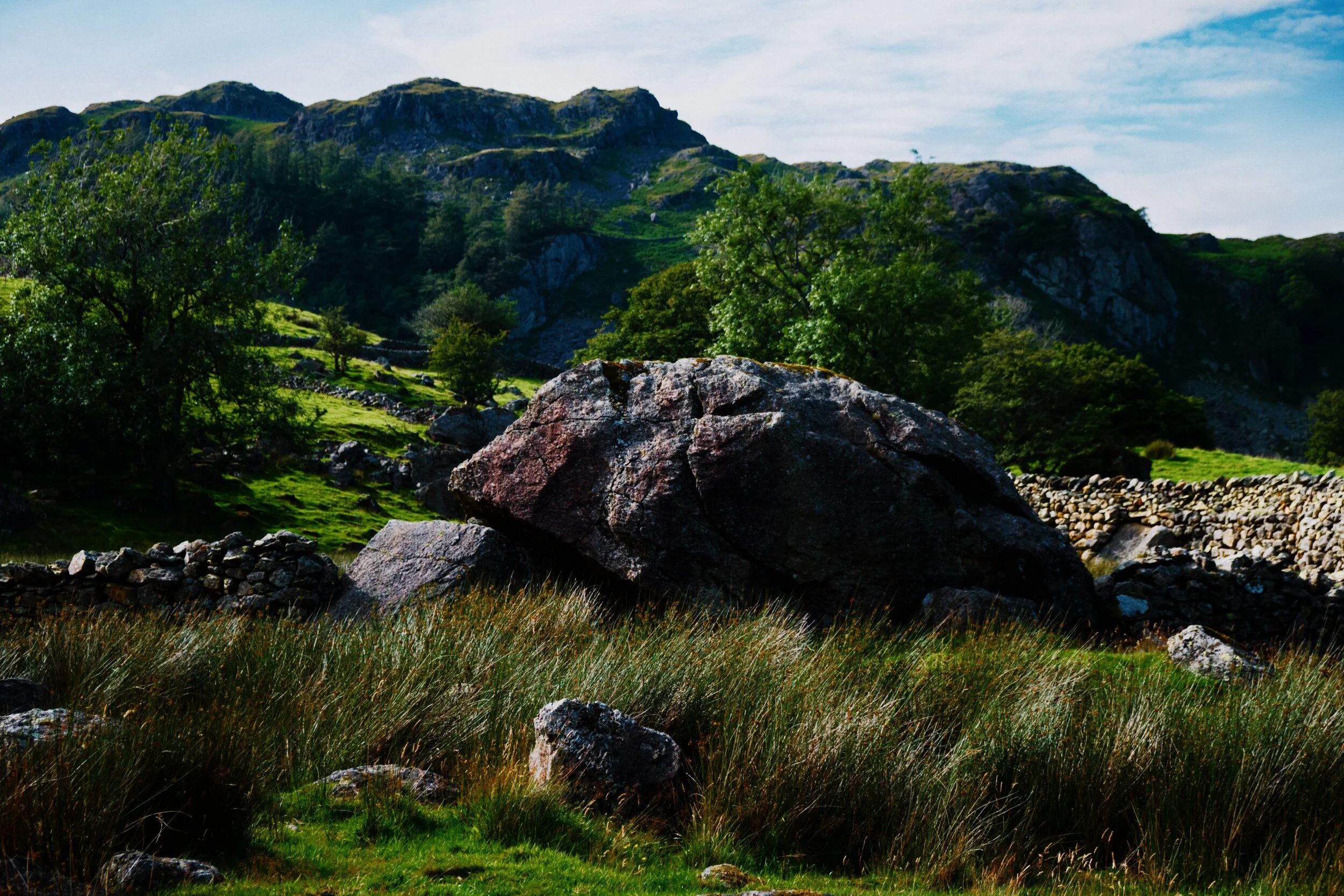  Rook Howe and Greenhead are home to quite a few glacial erratics with a large example featured here. In the background is the craggy eastern face of an area known as Crag Quarter, with minor peaks having such wonderful names as Cowsty Knotts, Raven Crag, and Calfhowe Crag. This area was almost certainly extensively mined. 