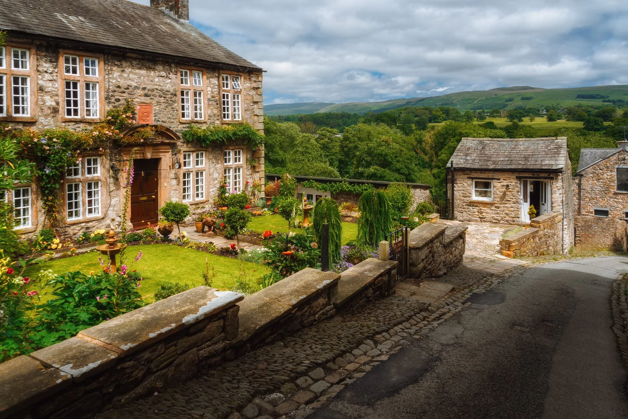  Another classic Kirkby Lonsdale view: Old Manor House on Mill Brow, with the Leck and Barbondale fells in the distance. And of course, during the summer, the House&rsquo;s gardens burst into colour. 