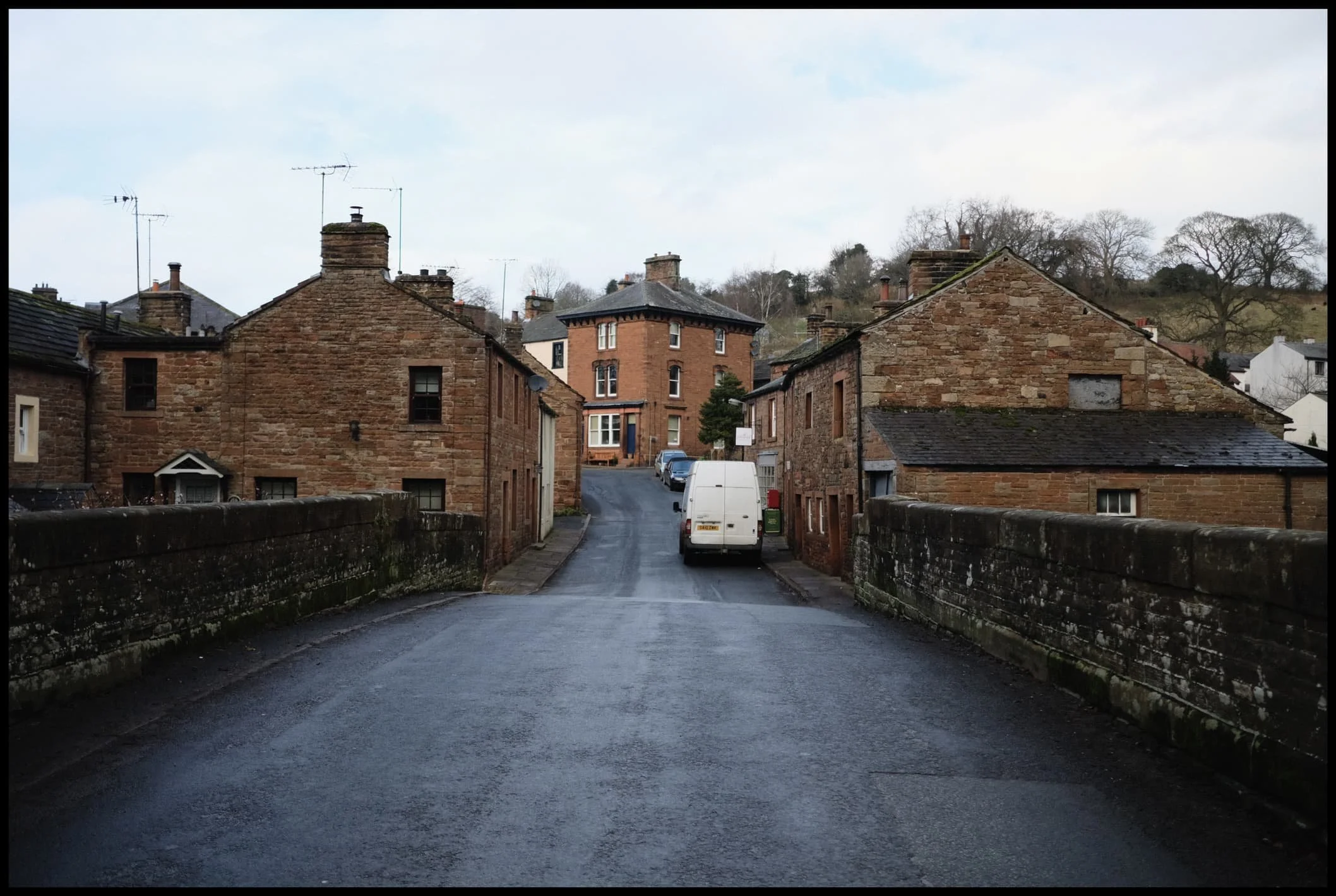  Crossing over the small bridge that spans Raven Beck. Ancient red sandstone buildings everywhere. 