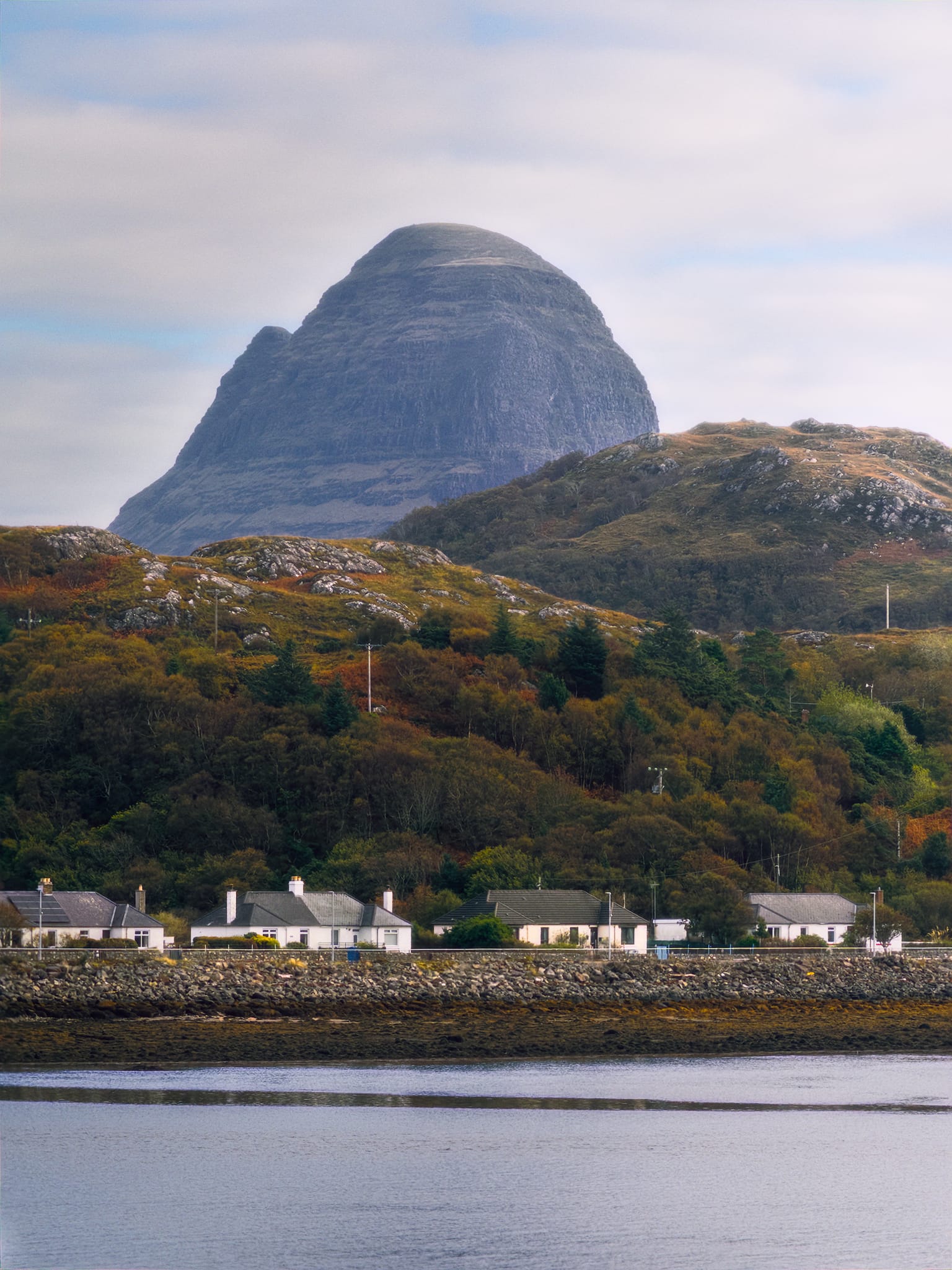After returning back to the car from trying to hike towards the Falls of Kirkaig, we explored Lochinver looking for shots across the loch. And near Highland Stoneware we got it. From this angle, Suilven presents as a formidable dome or pillar of a mountain, rising vertiginously above the village. It’s name, after all, comes from the Old Norse súla fjell, meaning “pillar mountain” (with the Gaelic bheinn eventually substituting the Old Norse fjell). Depending on your point of view, it presents as either protective or oppressive. To me she’s just astonishingly beautiful.