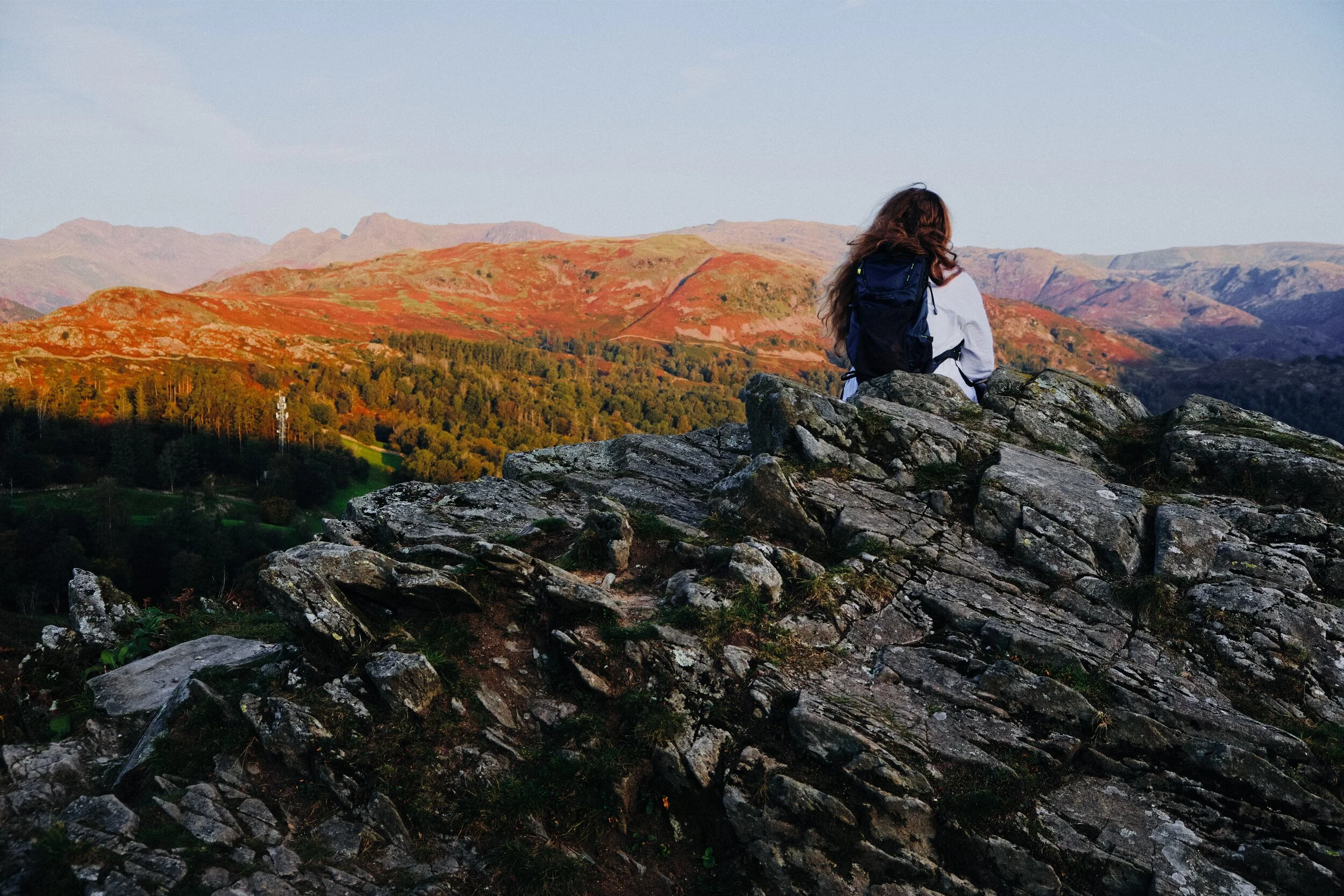  My lovely Lisabet takes a pew on some crag and enjoys the views as more of the fells light up in the sunrise glow. 