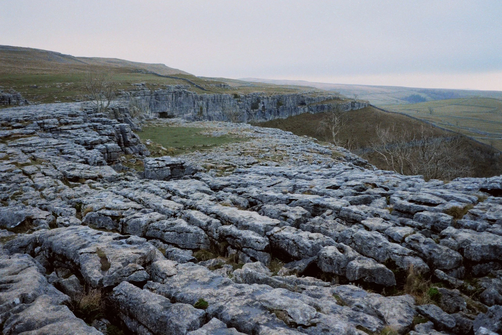  Limestone pavements occur when a glacier retreats and scours limestone, leaving behind a flat bed of rock. Limestone is slightly soluble in water, and rain is slightly acidic, so over time cracks form in the joints of the limestone. Give it a few thousand years or so, and this is the sort of landscape you&rsquo;re left with. 