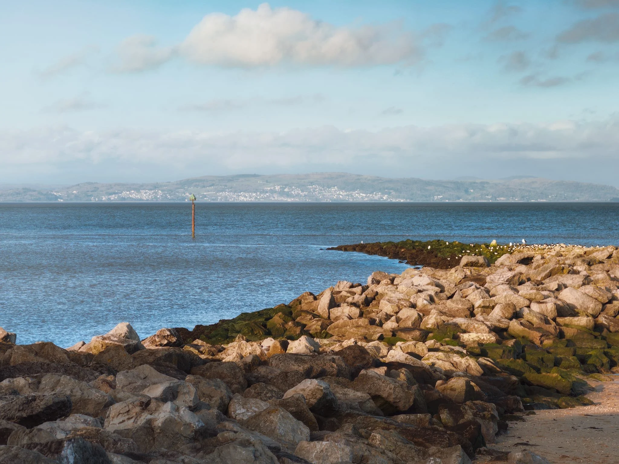  The clarity of light allowed for a zoomed in composition of one of Morecambe&rsquo;s bouldered breakwaters, using its curve as a leading line towards the distant Grange-over-Sands, all the way the other side of the bay. 