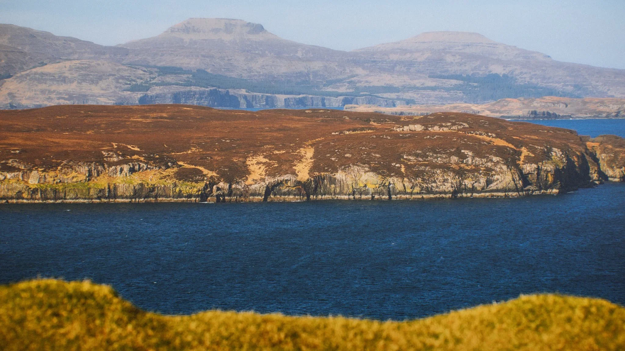 Looking further east, the eastern end of Wiay gives way to the two distinctive flat-topped hills on the Duirinish peninsula, known as MacLeod’s Tables. The one on the left―MacLeod’s Table South or Healabhal Bheag ―is 489 m/1,604 ft. The one on the right―MacLeod’s Table North or Healabhal Mhòr ―is 469 m/1,538 ft.