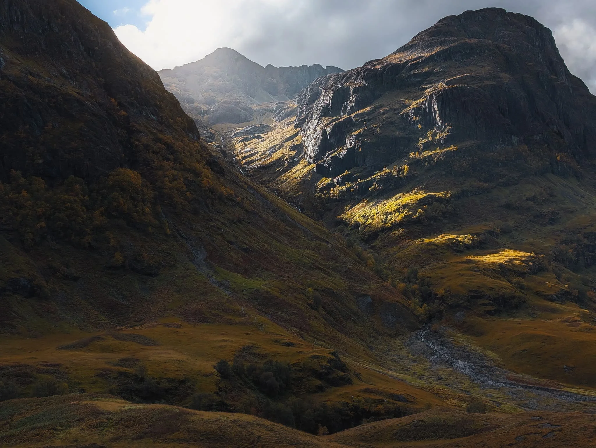 Autumnal light piercing between Geàrr Aonach and Aonach Dubh , illuminating the crags of Corrie nan Lochan . A perfect moment.