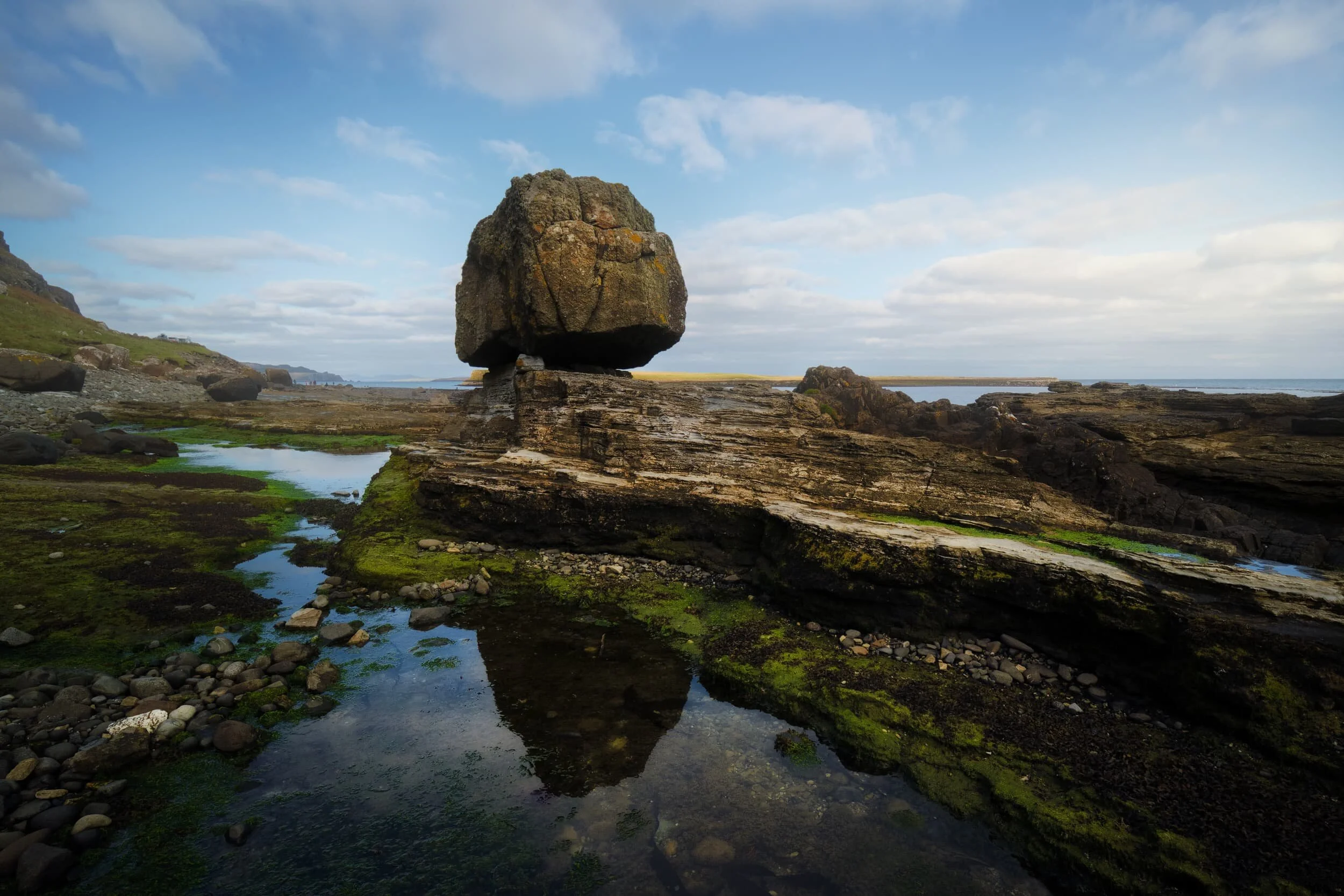 A reflection of the solitary perched glacial erratic, using the strata beneath it as a leading line.
