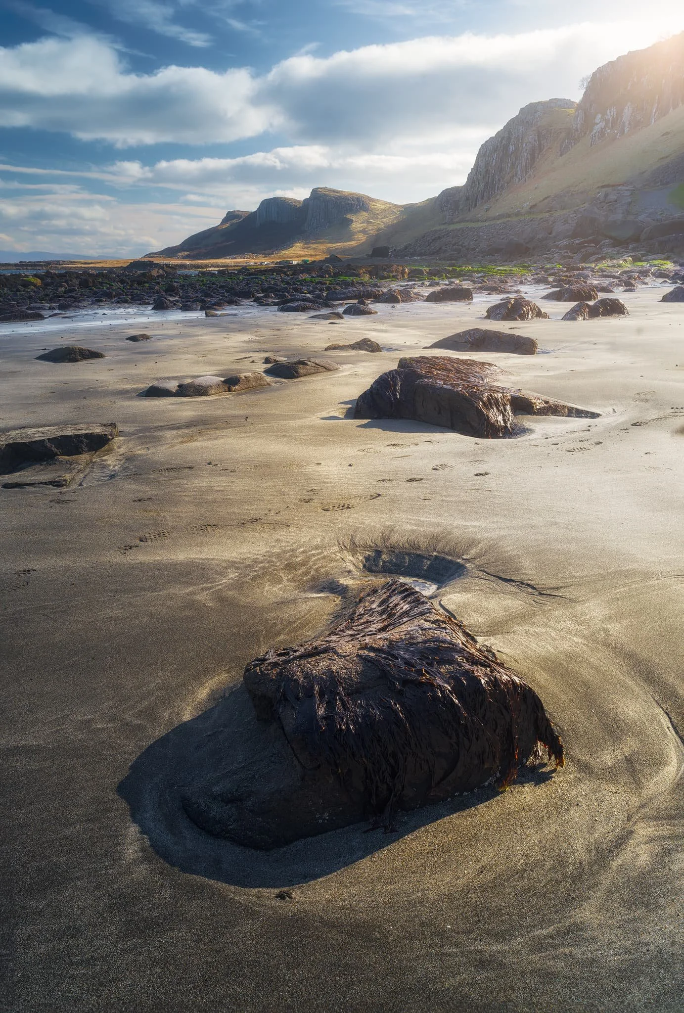  Further towards the northwest side of An Corran, the rocky coastline gives way to sand. I carefully navigate around, seeking a composition of these embedded boulders in the sand. 